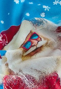 Bavlněná látka s potiskem Santa Clause v modrých slunečních brýlích, s červenou čepicí, bílým vousem a detaily sněhových vloček na modrém pozadí.