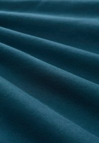 Donkerblauwe stof met een zachte, gladde textuur, met subtiele golven en plooien, en een egale kleur zonder patronen of zichtbare accenten.