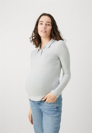 Light gray ribbed long-sleeve polo shirt with a collar, complemented by blue jeans. The fabric has a soft texture, fitted silhouette.