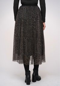 Gonna midi con stampa animale nera realizzata in tessuto leggero e trasparente. La vita è elastica e presenta una silhouette fluida con texture stratificata.