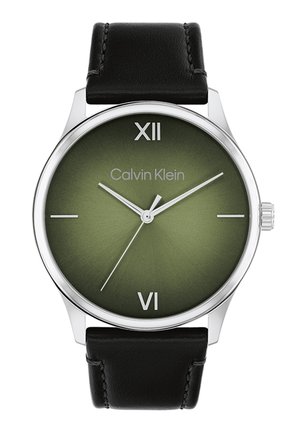 Montre Calvin Klein avec un boîtier circulaire en acier inoxydable, un cadran dégradé vert, un bracelet en cuir noir, les chiffres romains XII et VI, et des aiguilles en argent.