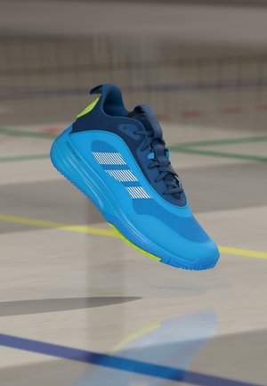 Sportowy but typu sneaker w kolorze niebieskim z zielonymi akcentami, wyposażony w teksturowaną siateczkową cholewkę, odblaskowe paski oraz amortyzowaną podeszwę dla wsparcia.