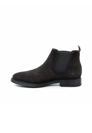 Schwarze Wildleder-Chelsea-Stiefel mit elastischen Seitenpaneelen, runder Zehenform, strukturiertem Finish und niedrigem Blockabsatz. Roter Akzent an der Rückseite.