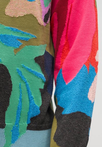 Κοντινή λήψη πολύχρωμου πλεκτού υφάσματος με αφηρημένα λουλουδένια μοτίβα σε ελαιώδη, μπλε, ροζ, κόκκινες και μαύρες κλωστές με υφή.