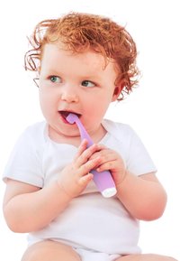 Barn som håller en lila tandborste med ett böjt handtag och mjuka borst, iförd en vit skjorta. Ljus hud och lockigt rött hår.