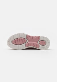 Suela de zapatilla Skechers que presenta una sección central rosa, goma blanca con patrones texturizados y el detalle de marca "ULTRA GO".