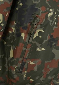 Camouflage fabric with a vertical zippered pocket featuring a paracord zipper pull in green, brown, black, and beige tones.