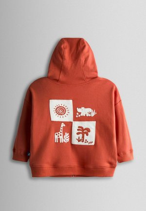 Terrakotta kapucnis pulóver elülső zsebbel. Fehér hímzett négyzetek állat- és napmintákkal díszítve. Puha pamut anyag, normál szabás.