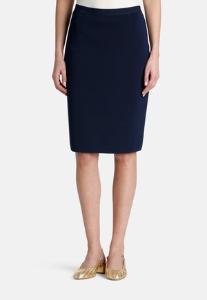 Sininen kynähame, valmistettu teksturoidusta kankaasta, jossa on sileä vyötärö ja takareikä, yhdistetty kultaisiin kudottuihin slingback-kengiin.