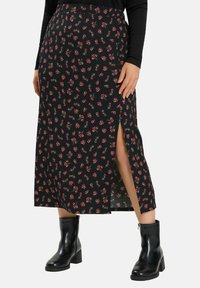 Musta kukallinen midi-hame, jossa on punaisia ruusukuvioita, sivuhalkio, ribbikuvioitu pinta, yhdistetty mustiin nilkkasaappaisiin.