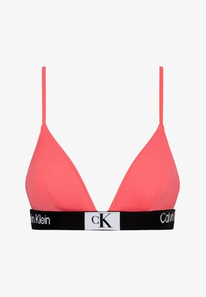 Roza trikotna bralette iz mehkega materiala, ki ima tanke nastavljive naramnice in črn elastičen trak z belo logotipsko podrobnostjo.