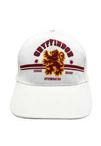 Witte baseballpet met het Gryffindor-wapen en een leeuw afbeelding. Tekst luidt "Gryffindor," "Moed," "Vastberadenheid," en "Dapperheid" in het rood.