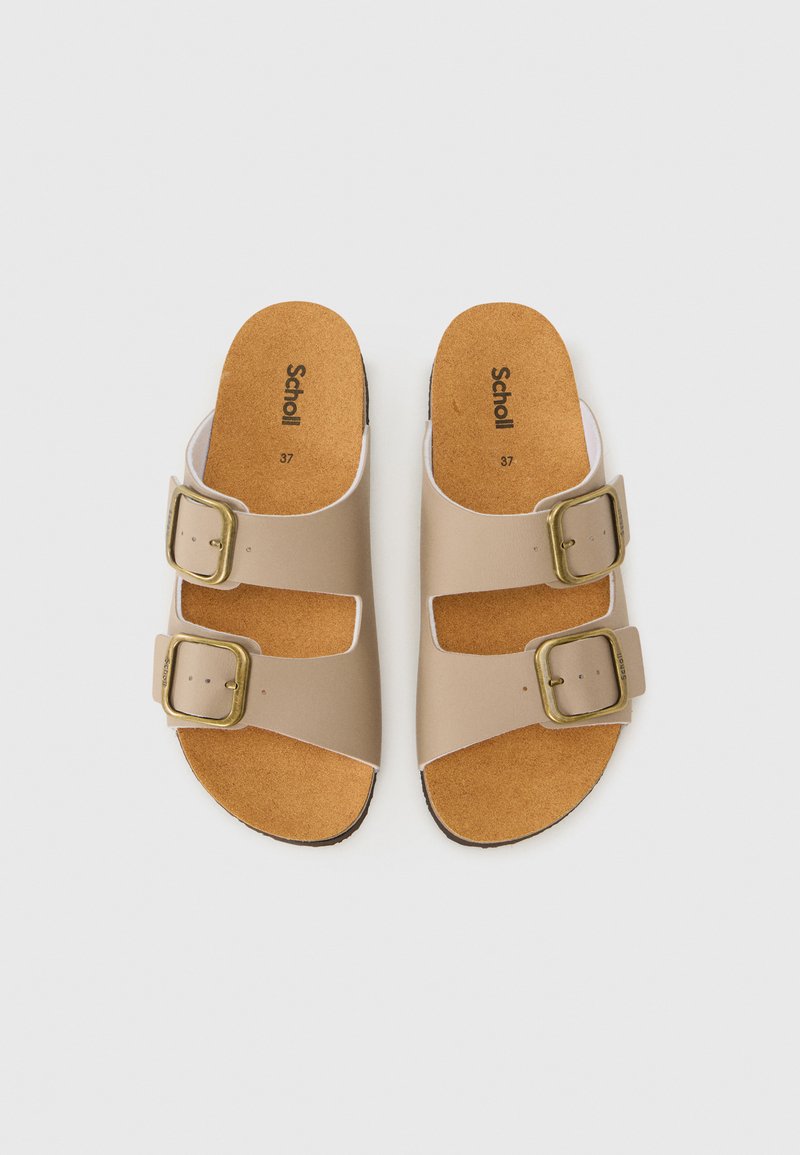 Sandales beiges avec deux boucles réglables, semelle en liège et accent blanc le long des sangles. Semelle plate, design simple, taille 37.