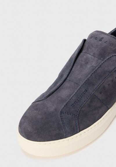 Men's dark blue suede slip-on sneaker with white rubber sole and subtle stitching details on a plain background.