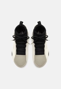 Czarne i jasnoszare sneakersy z wysokim cholewką, teksturowanym wierzchem, płaskimi sznurówkami i gładkim noskiem; z pętlą z tyłu.