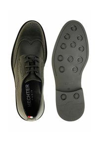 Schwarze Lederschuhe mit Lochdetails und Wingtips-Design. Gummisohle mit rundem Profil. Größe 42.