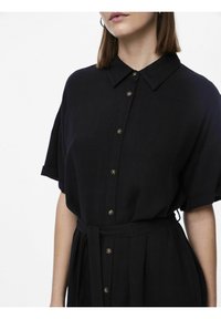 Abito nera con bottoni, colletto, maniche corte e vita legata. Presenta bottoni metallici e un tessuto leggero e strutturato.