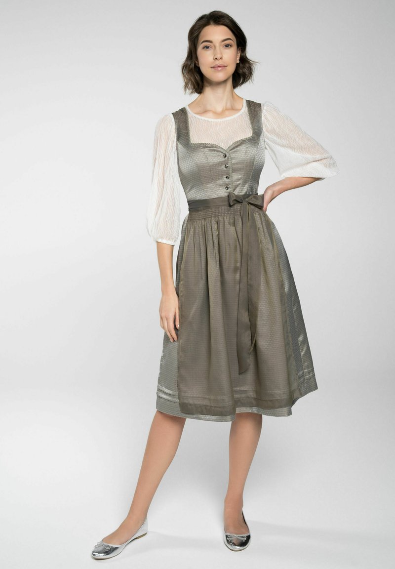 Traditionelles Kleid mit einem taillierten Oberteil, puffigen Ärmeln und einem fließenden grauen Rock. Verfügt über dekorative Knöpfe und einen gebundenen Gürtel.