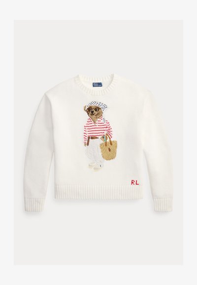 Λευκό πλεκτό πουλόβερ με κέντημα ενός σκύλου που φορά γυαλιά ηλίου, ριγέ πουκάμισο, λευκό παντελόνι, κρατώντας μια πλεκτή τσάντα tote και τα αρχικά "RL".