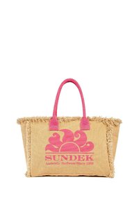 Sac de plage en fibre naturelle avec bordures à franges. Poignées roses et décor graphique présentant un design de soleil rose. Grande taille et texture.