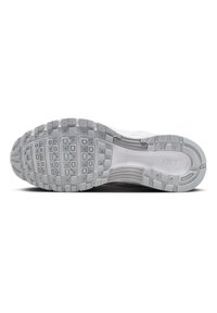 Semelle d'une chaussure de course Nike blanche avec motif de grip texturé et amorti Air visible au niveau du talon.