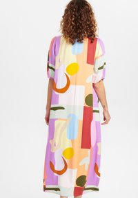 Robe multicolore avec des formes abstraites en orange, rose, bleu et vert. Confectionnée dans un tissu léger avec des manches courtes bouffantes.