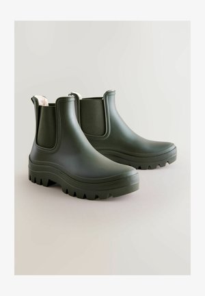 Grüne Gummistiefel mit dicken, strukturierten Sohlen und elastischen Seitenpanelen, ausgestattet mit einem weichen Innenfutter und einem abgerundeten Zehenbereich.