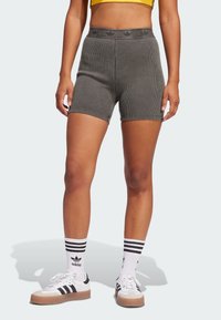 Gray ribbed shorts with a high waistband, paired with white sneakers featuring black stripes and matching striped socks.