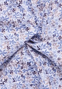 Stof met blauwe en bruine bloempatronen op een lichte achtergrond, met draaiende ontwerpen en een zachte, gestructureerde uitstraling.