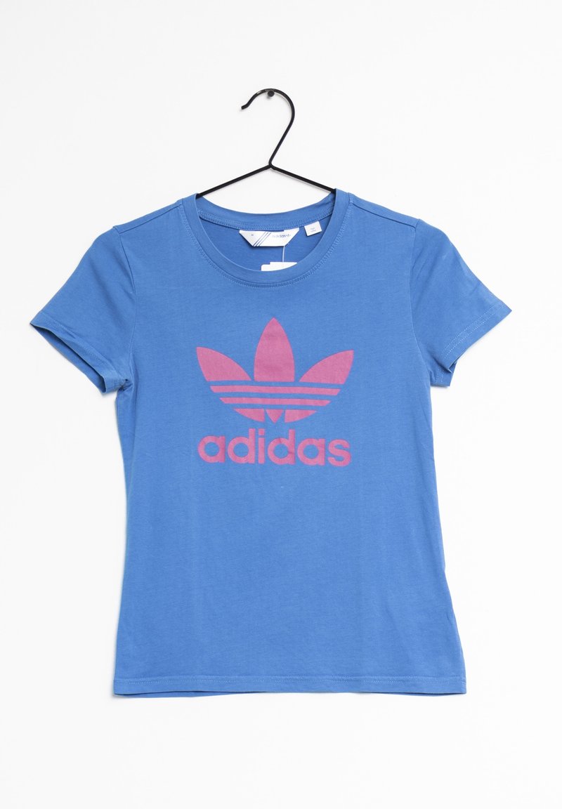 Modrá bavlněná tričko s krátkými rukávy a kulatým výstřihem, které má velké růžové logo Adidas a tři proužky nad ním.