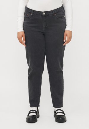 Black denim jeans with a straight fit, five pockets, and a button closure, paired with black shoes and white socks.