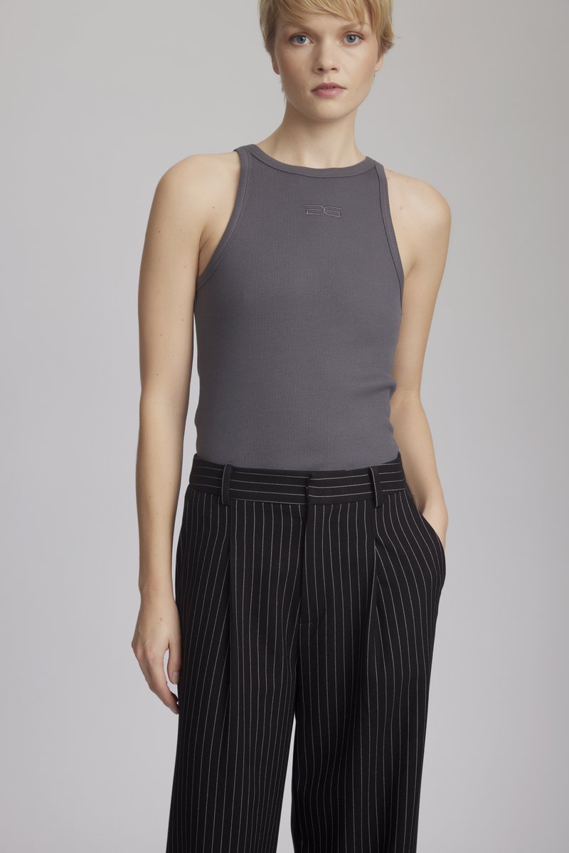 Grå ribbestrikket tanktopp med høy utringning, kombinert med svarte bukser med pinstriper som har frontfolder og sidelommer.