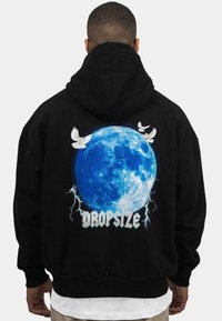 Sudadera negra con un gran gráfico de una luna azul, adornado con palomas blancas y relámpagos, etiquetada "DROPSIZE" en un texto estilizado en la parte inferior.