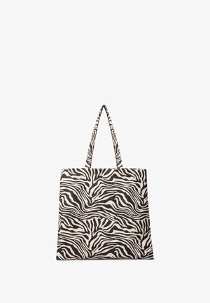 Borsa tote in canvas con design a strisce di zebra in bianco e nero, dotata di due manici lunghi e una forma rettangolare strutturata.