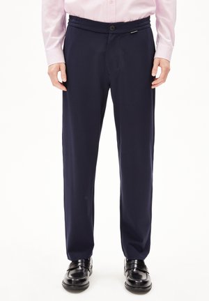 Marineblaue Hose mit lockerer Passform, elastischem Bund und einem einzigen Knopfverschluss. Das Design zeichnet sich durch eine glatte Textur und einen vorderen Bügelfalte aus.
