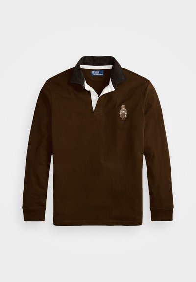Bruine langemouw polo shirt met een wit en zwart kraag, voorzien van een geborduurd ontwerp op de borst. Gladde stof, ontspannen pasvorm.