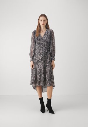Black and white snake print dress with long, sheer sleeves, a V-neckline, and a drawstring waist. Styled with black suede ankle boots.