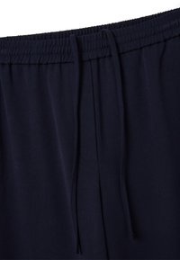 Marineblauwe broek met een elastische tailleband, trekkoorddetail en een gladde structuur, met zijzakken.