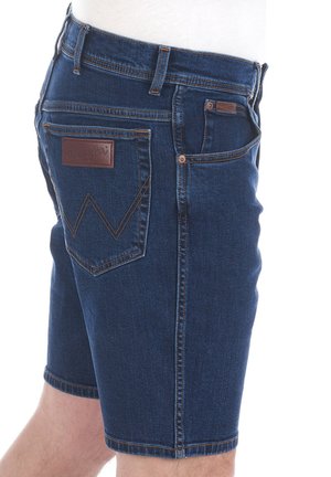 Jeansshorts in donkerblauw, met een klassieke snit, vijf zakken en een lederen label met een logo op de achterkant. Contrasterende stiksels.
