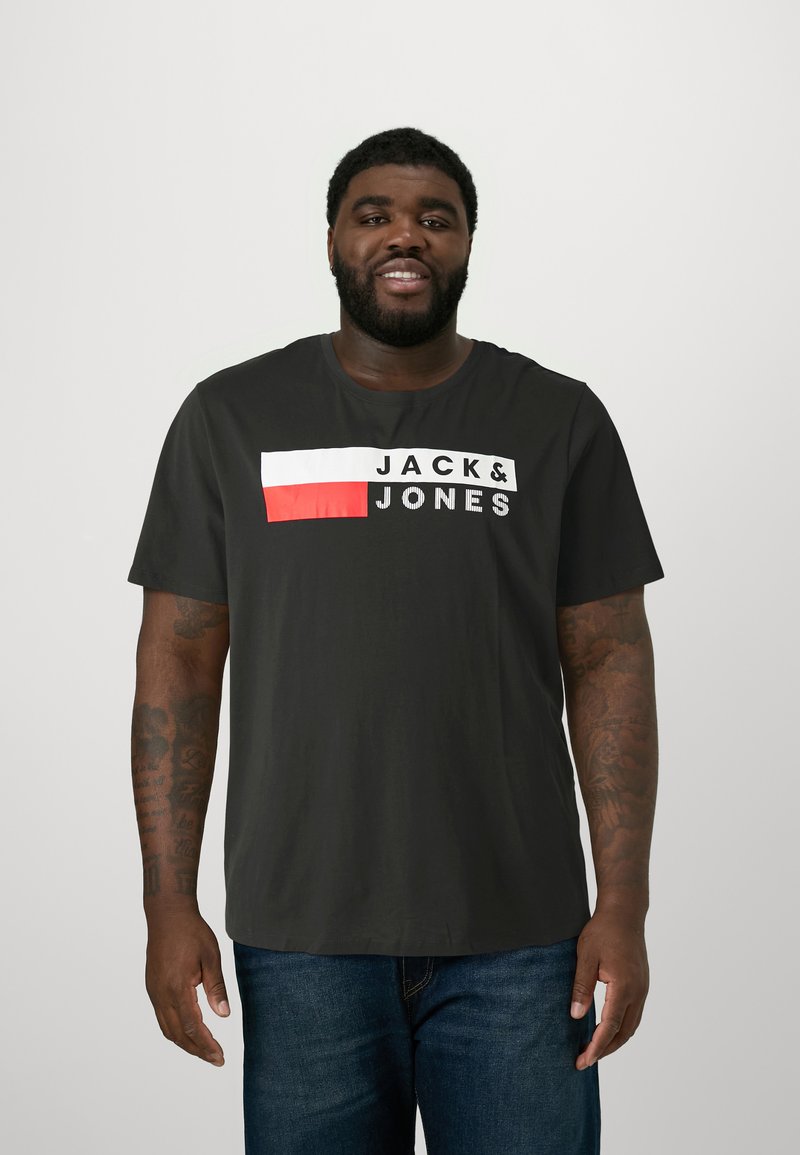 Black short-sleeve t-shirt featuring a white and red horizontal block graphic with "JACK&JONES" text in bold, contrasting white letters.