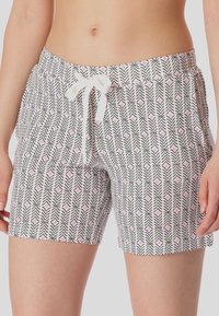 Patronen zwemshorts in het wit met zwarte zigzag en roze diamanten ontwerpen, met een verstelbare tailleband. Gemaakt van lichtgewicht materiaal.