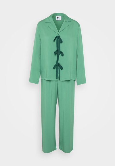Green two-piece outfit featuring a loose-fitting top with a collar and bow tie detail, and matching wide-leg pants, both in a smooth fabric.