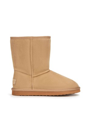 Zamszowy, średniej długości kozaki w kolorze ruda z widocznym przeszyciem, płaską gumową podeszwą i zaokrąglonym czubkiem, zaprojektowany na co dzień.