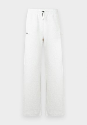 Jasnoszare spodnie dresowe wykonane z miękkiego materiału, z czarnym ściągaczem, bocznymi kieszeniami oraz małym czarnym logo Nike na lewej biodrze.