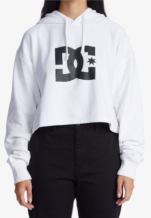 Weißer, kurzer Kapuzenpullover mit einem schwarzen DC-Logo und Stern-Grafik auf der Vorderseite. Das Material wirkt weich, mit einer Kordelkapuze und gerippten Bündchen.