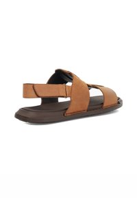 Brown leather sandal with multiple straps and an adjustable back; features a textured surface and a flexible rubber sole.