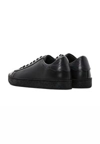 Black leather sneakers with a smooth finish, rounded toe, lace-up front, and textured black rubber sole. Accented heel detail.