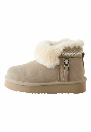Tan suede ankle boot featuring a faux fur cuff, decorative stitching, a side zipper, and a textured rubber sole.