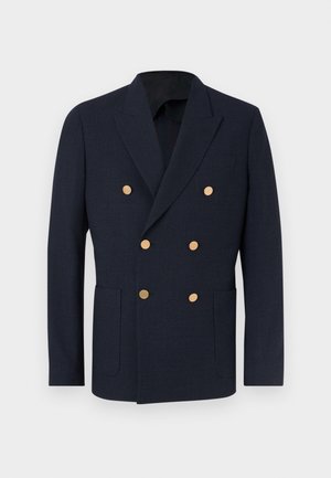 Tengerészkék, dupla soros zakó texturált anyagból, hat aranygombbal és két elülső zsebbel. Vágott hajtókák és sima belső bélés.