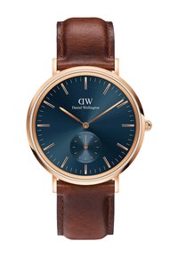 Orologio con cinturino in pelle marrone, quadrante blu navy, lancette e indici delle ore in tono dorato. Presenta un sottodial più piccolo per i secondi.